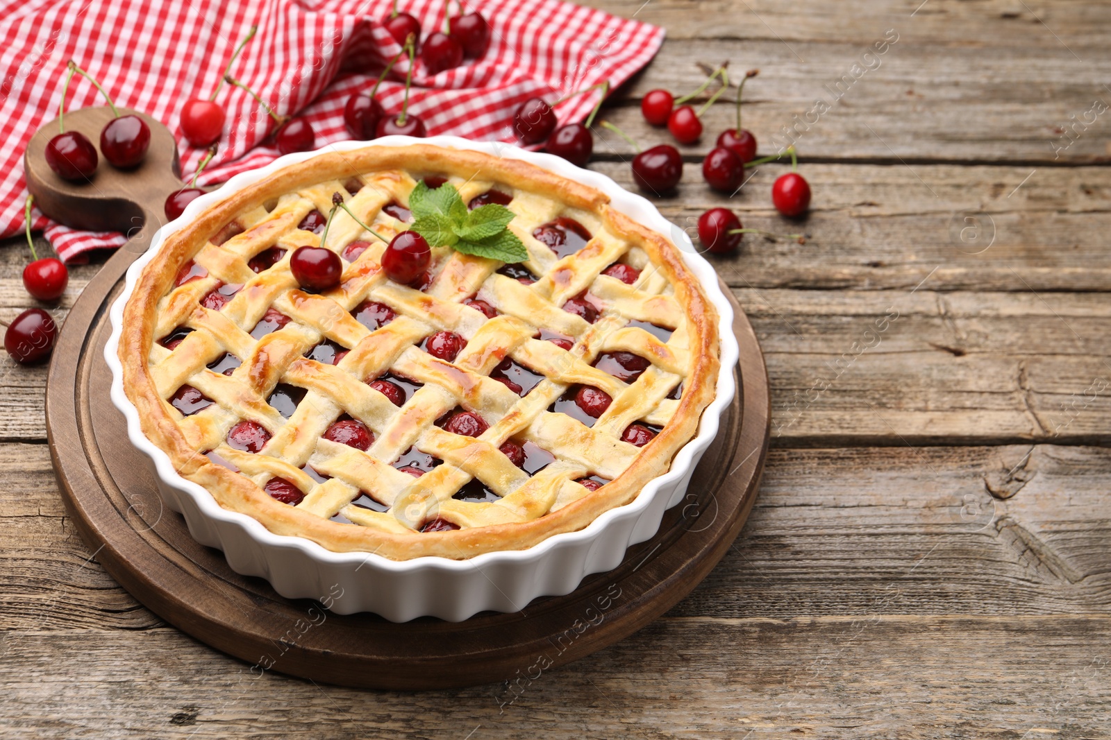 Photo of Tasty cherry pie on wooden table, closeup. Space for text