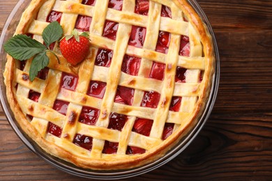 Photo of Tasty strawberry pie on wooden table, top view
