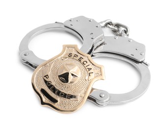 Photo of Police badge and handcuffs on white background