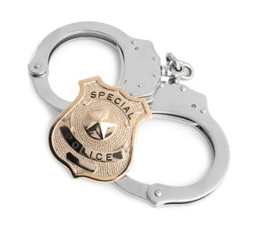 Photo of Police badge and handcuffs on white background, above view