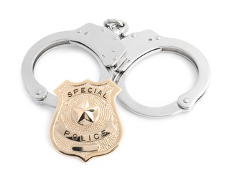 Photo of Police badge and handcuffs on white background, above view
