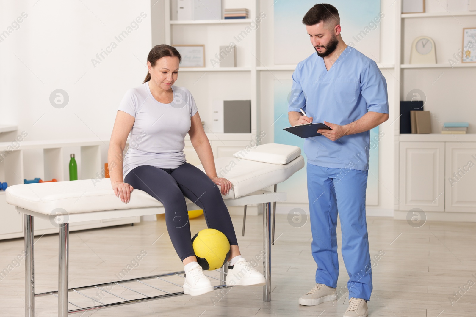 Doctor and patient exercising with medicine ball in clinic Photo of Doctor and patient exercising with medicine ball in clinic