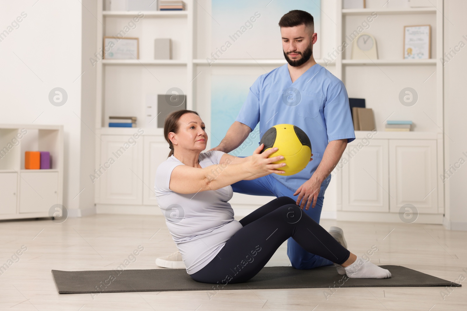 Doctor and patient exercising with medicine ball in clinic Photo of Doctor and patient exercising with medicine ball in clinic