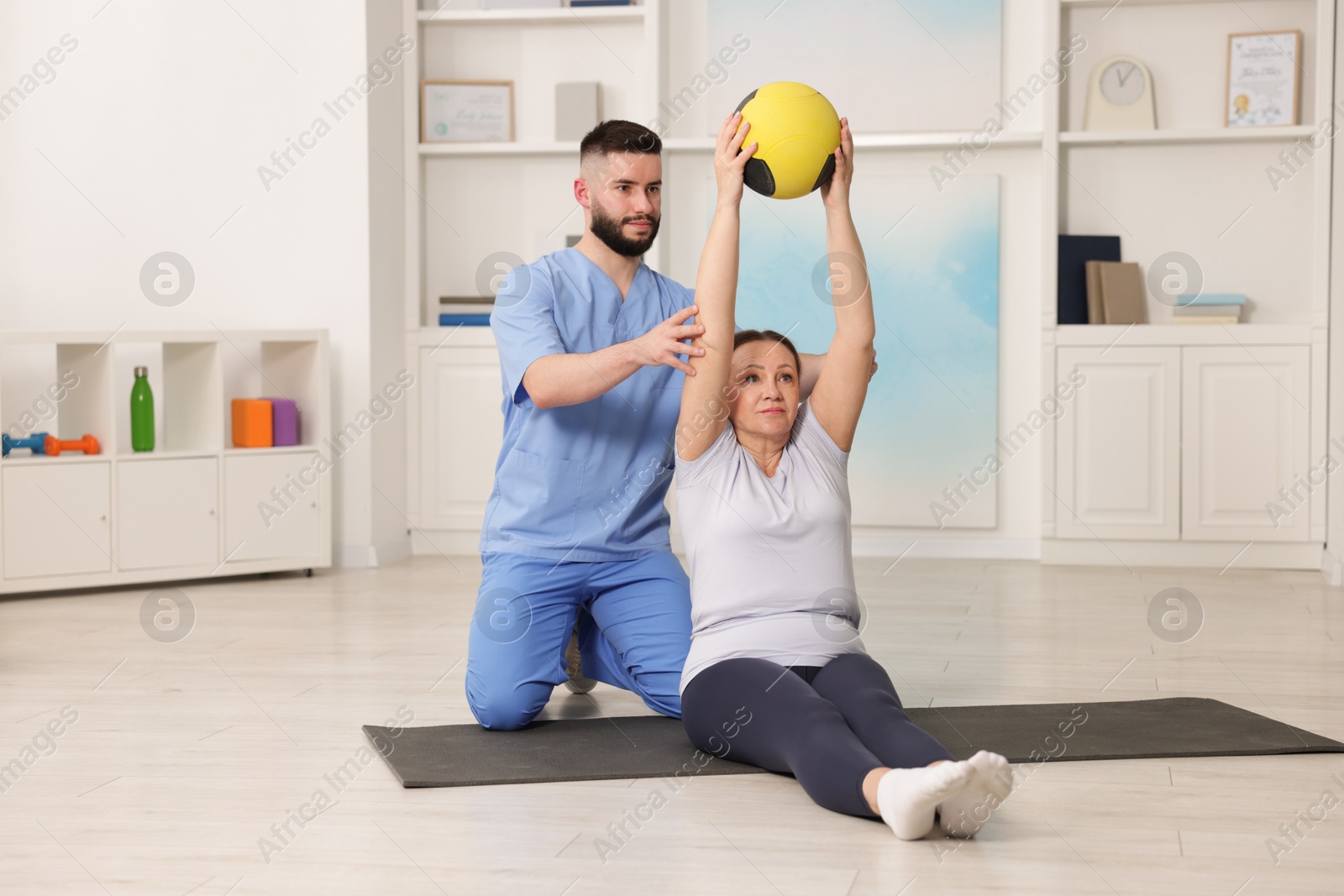 Doctor and patient exercising with medicine ball in clinic Photo of Doctor and patient exercising with medicine ball in clinic