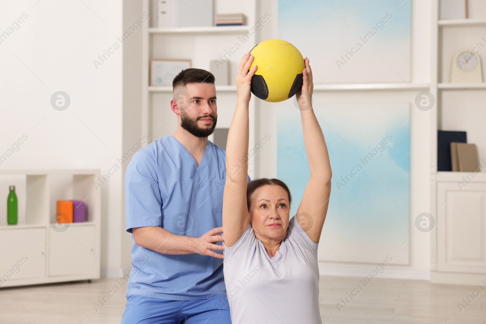 Doctor and patient exercising with medicine ball in clinic Photo of Doctor and patient exercising with medicine ball in clinic