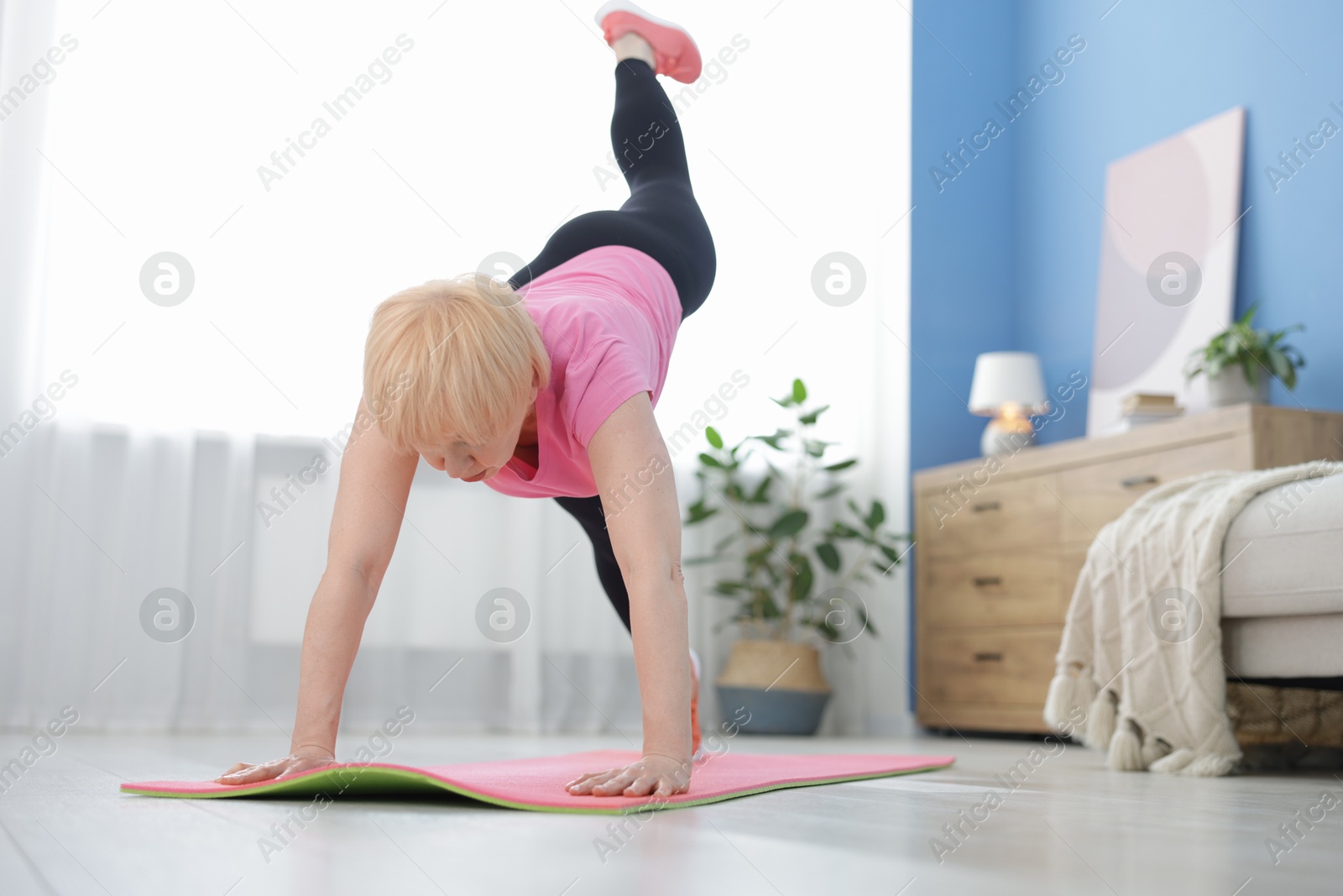 Photo of Senior woman in sportswear doing plank exercise at home, space for text