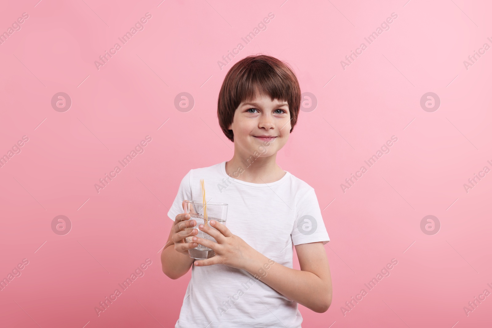 Cute little boy with glass of refreshing soda drink on pink background Photo of Cute little boy with glass of refreshing soda drink on pink background
