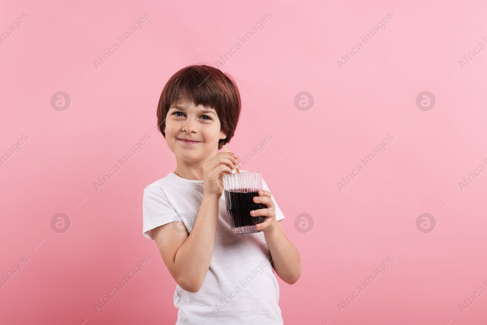 Cute little boy with glass of refreshing soda drink on pink background Photo of Cute little boy with glass of refreshing soda drink on pink background