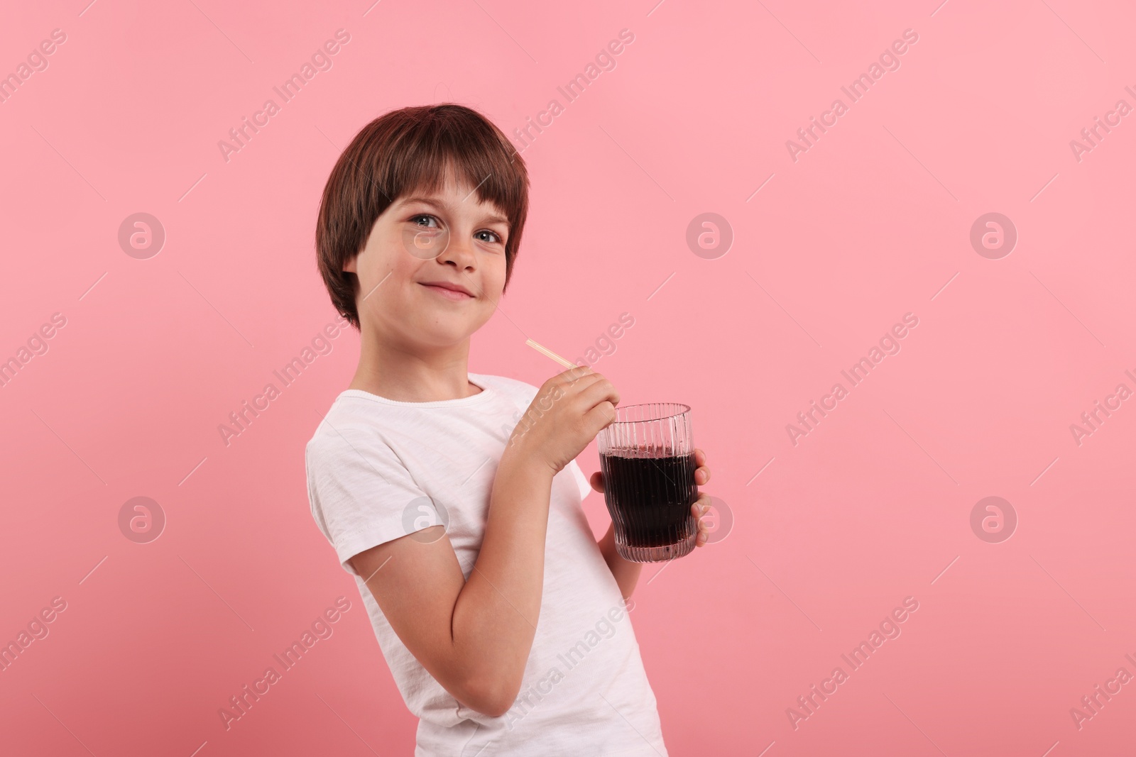 Cute little boy with glass of refreshing soda drink on pink background Photo of Cute little boy with glass of refreshing soda drink on pink background