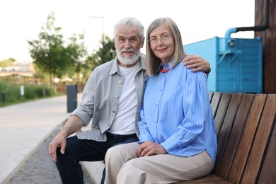 Photo of Lovely senior couple on bench near building outdoors