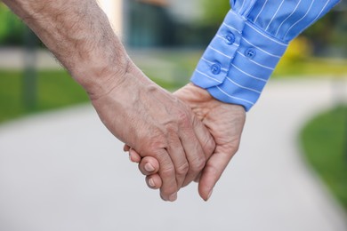 Photo of Lovely senior couple walking together outdoors, closeup