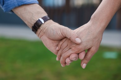 Photo of Lovely senior couple walking together outdoors, closeup