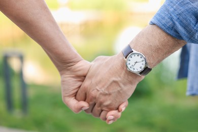 Photo of Lovely senior couple walking together outdoors, closeup