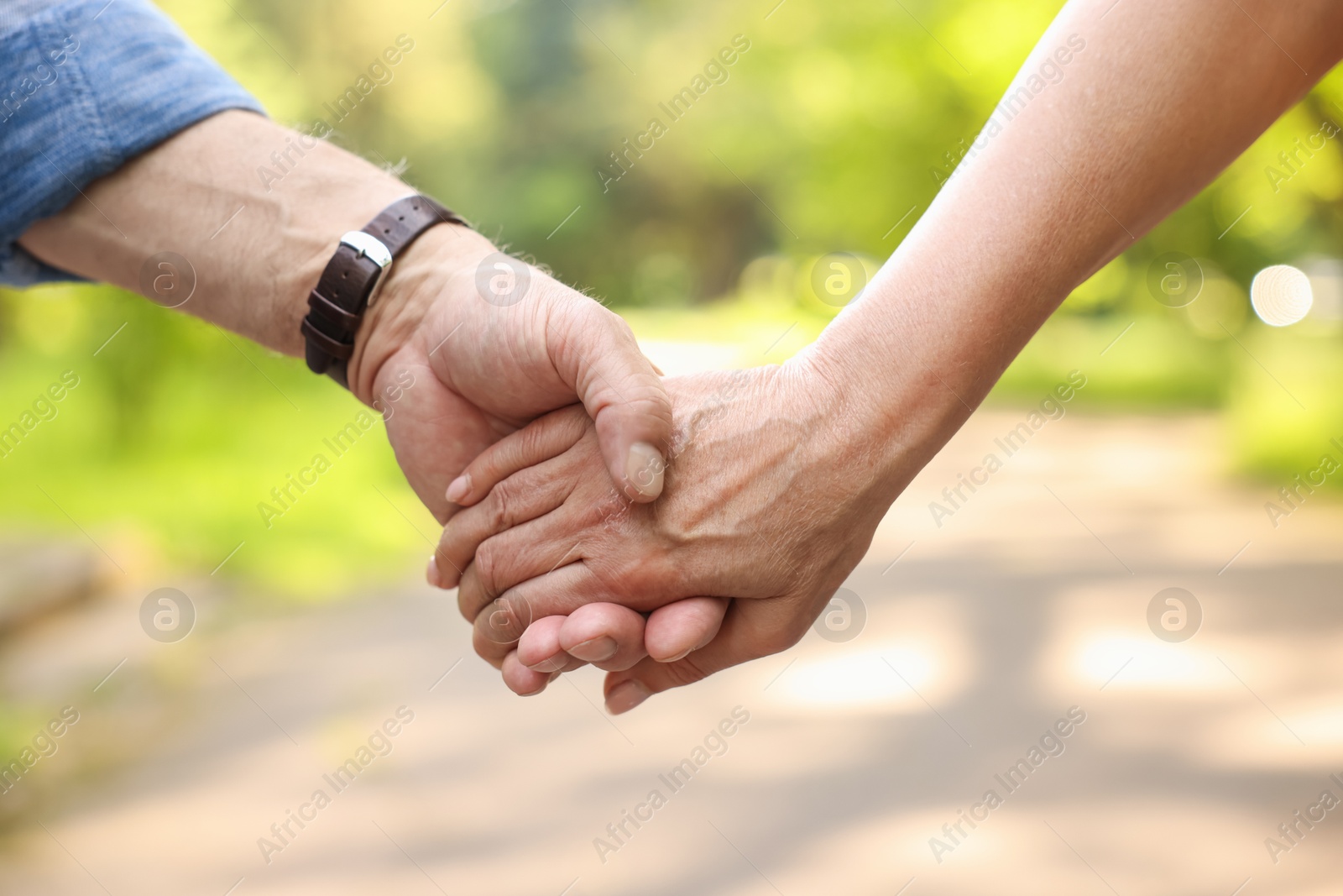 Lovely senior couple walking together outdoors, closeup Photo of Lovely senior couple walking together outdoors, closeup