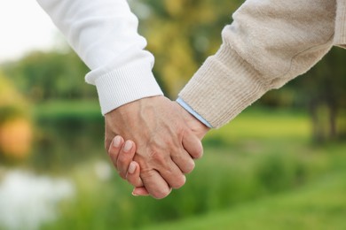 Photo of Lovely senior couple walking together outdoors, closeup