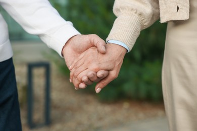 Photo of Lovely senior couple walking together outdoors, closeup