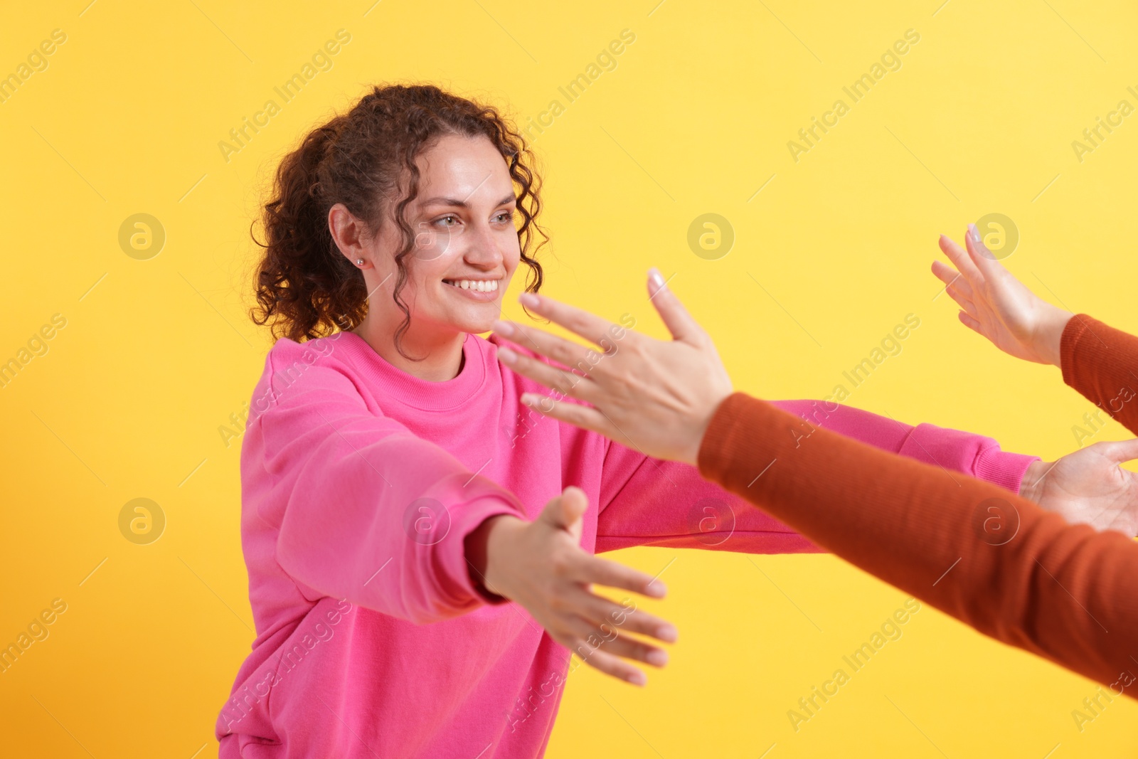 Photo of Friends welcoming each other on orange background, closeup