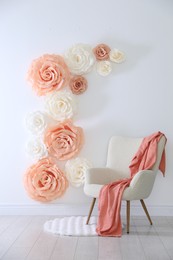 Photo of Photo zone with beautiful floral decor and armchair in studio