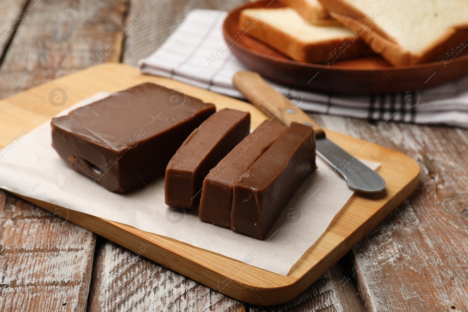 Tasty chocolate butter, slices of bread and knife on wooden table, closeup Photo of Tasty chocolate butter, slices of bread and knife on wooden table, closeup