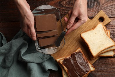 Photo of Woman with tasty chocolate butter and knife at wooden table, top view