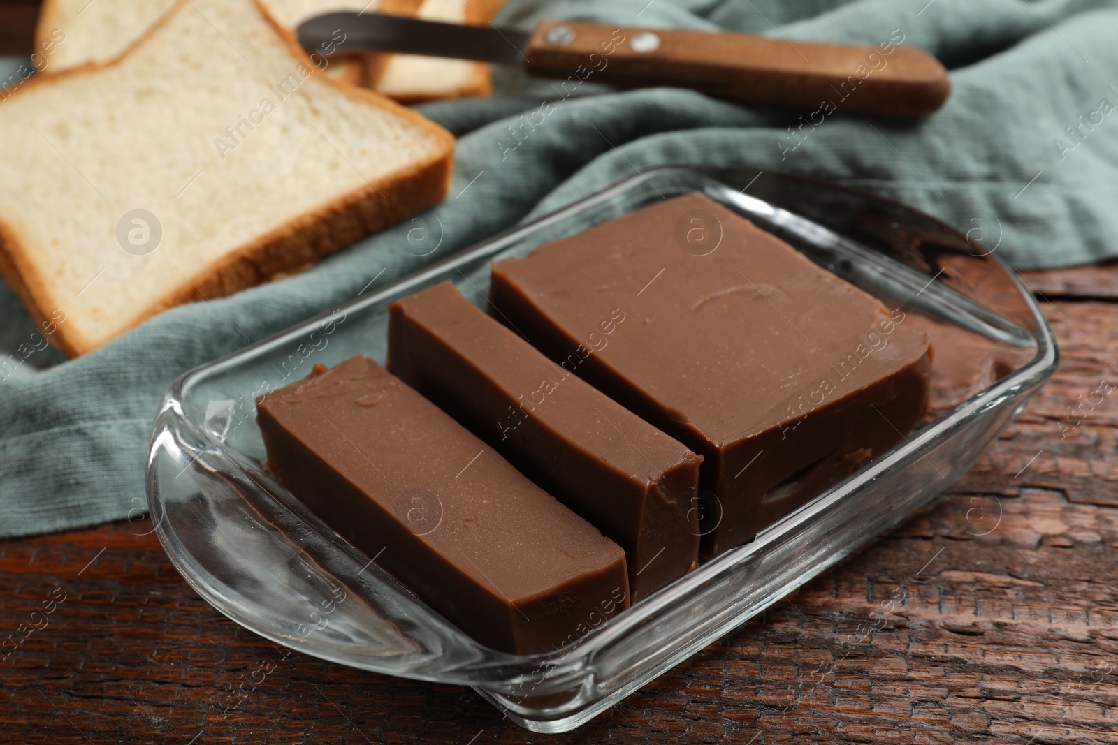 Tasty chocolate butter, slices of bread and knife on wooden table, closeup Photo of Tasty chocolate butter, slices of bread and knife on wooden table, closeup