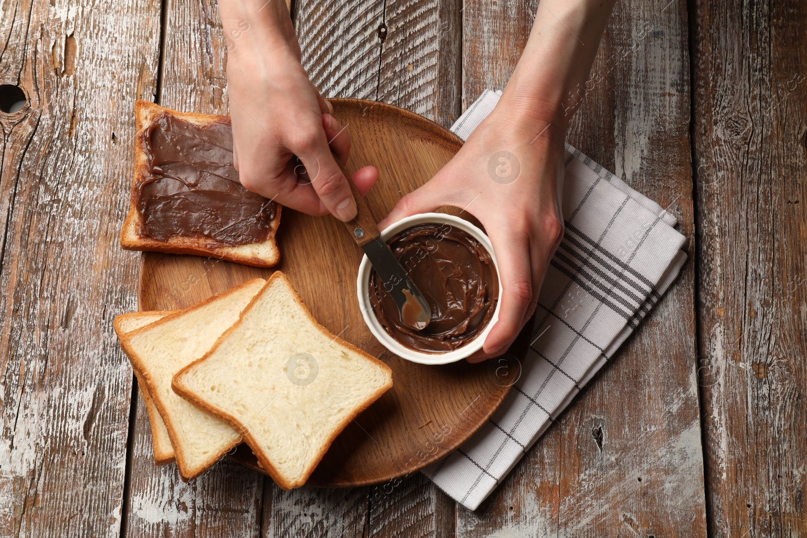 Woman with tasty chocolate butter and knife at wooden table, top view Photo of Woman with tasty chocolate butter and knife at wooden table, top view