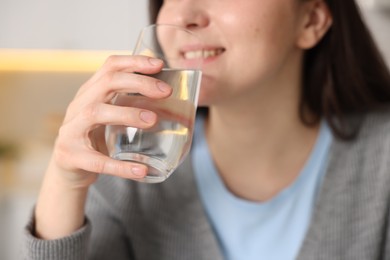 Photo of Woman drinking water from glass in kitchen, closeup
