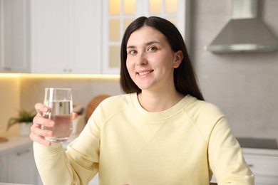 Photo of Woman with glass of water in kitchen