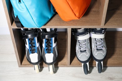 Photo of Pairs of roller skates and backpacks in shelving unit