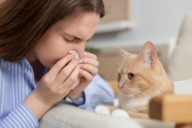 Photo of Woman suffering from allergy with her cat at home