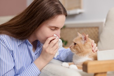 Photo of Woman suffering from allergy with her cat at home