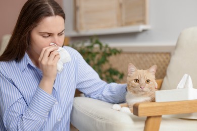 Photo of Woman suffering from allergy with her cat at home