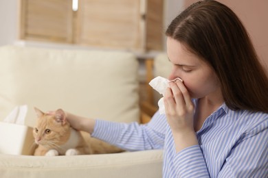 Photo of Woman suffering from allergy with her cat at home