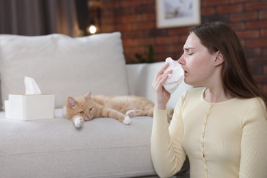 Photo of Woman suffering from allergy with her cat at home