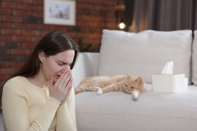 Photo of Woman suffering from allergy with her cat at home