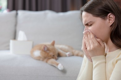 Photo of Woman suffering from allergy with her cat at home, selective focus