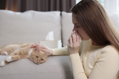 Photo of Woman suffering from allergy with her cat at home