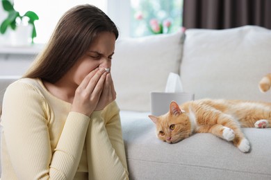 Photo of Woman suffering from allergy with her cat at home
