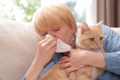 Photo of Senior woman suffering from allergy with her cat at home
