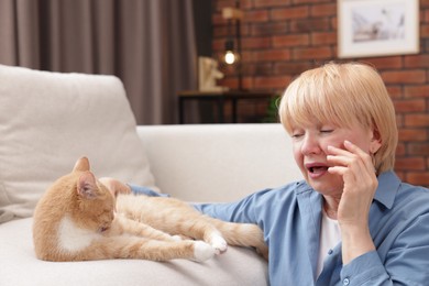 Photo of Senior woman suffering from allergy with her cat at home