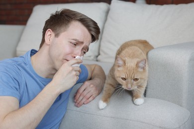 Photo of Man suffering from allergy with his cat at home