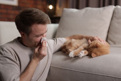 Photo of Man suffering from allergy with his cat at home
