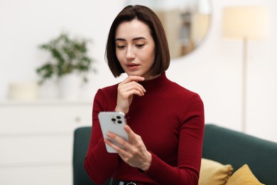 Photo of Beautiful woman using modern smartphone at home