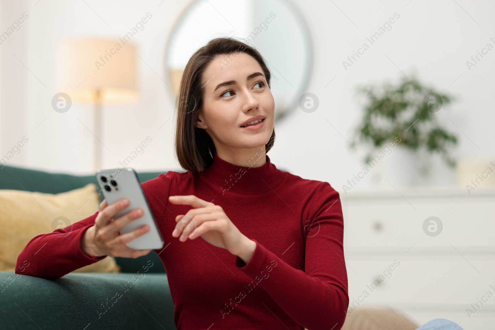 Beautiful woman using modern smartphone at home Photo of Beautiful woman using modern smartphone at home
