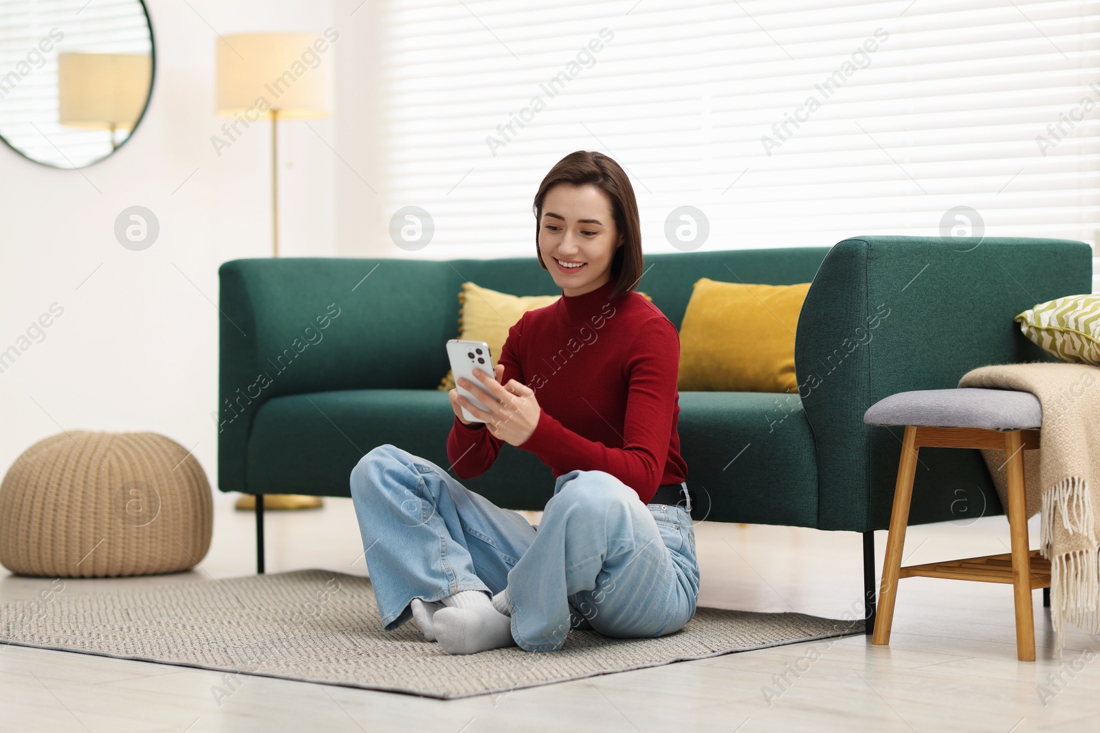 Woman using modern smartphone on floor at home Photo of Woman using modern smartphone on floor at home