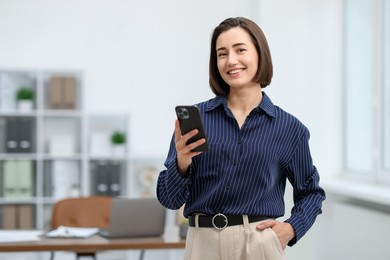Photo of Beautiful woman using her smartphone in office. Space for text