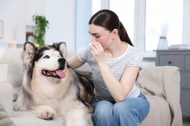 Photo of Woman suffering from allergy with her dog at home