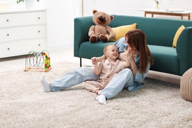 Photo of Mother spending time together with her happy son on floor at home