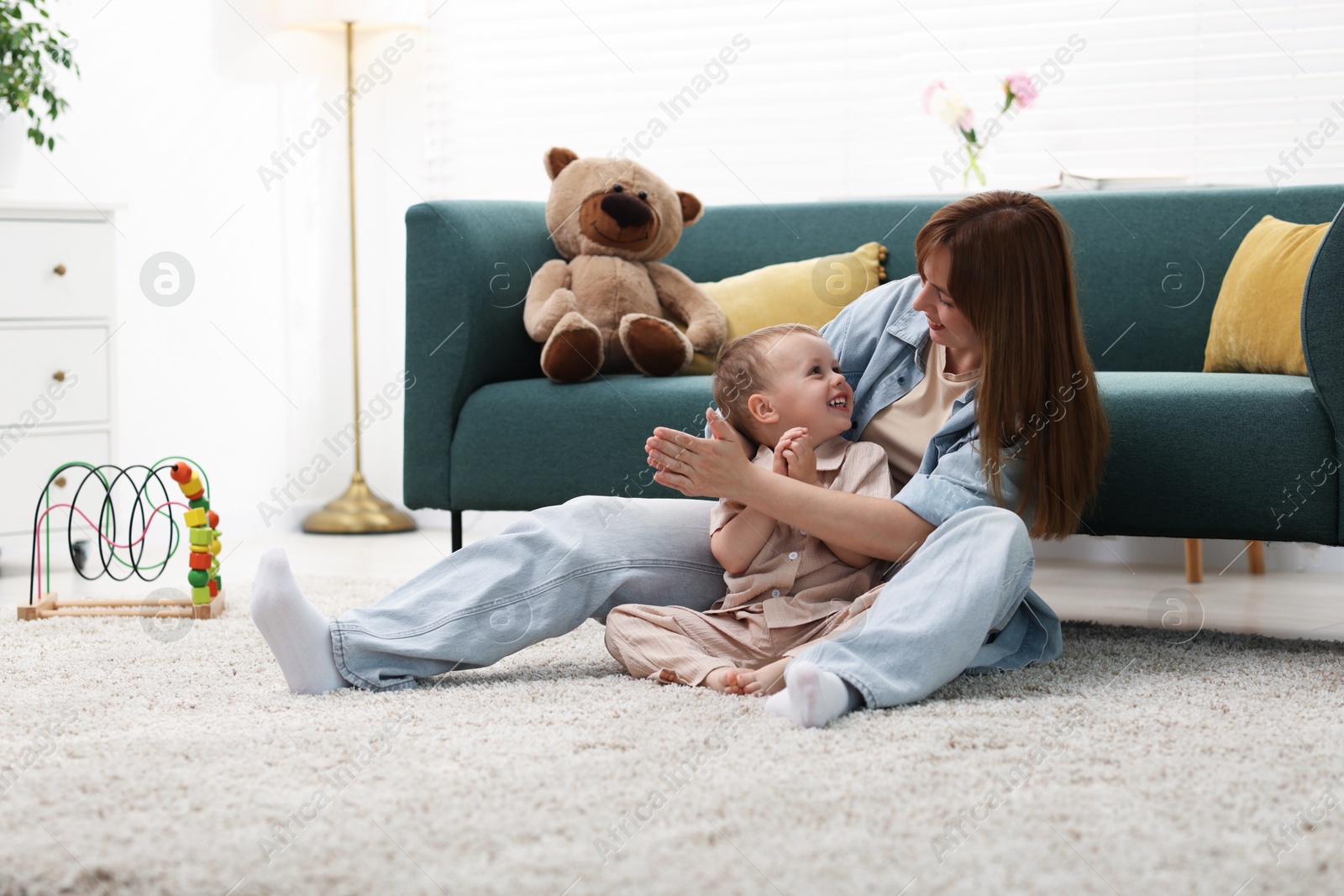Happy mother spending time together with her son on floor at home Photo of Happy mother spending time together with her son on floor at home