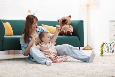 Photo of Happy mother spending time together with her son on floor at home